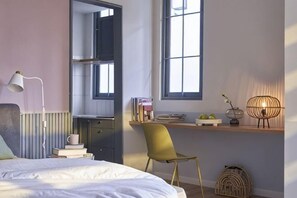 A bedroom with a bed, a desk, a chair, a window, and a lamp. - Express by M Village Ly Chinh Thang, a brand of Modern Village Lifestyle (Ho Chi Minh City)