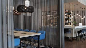 A modern bar area with a checkered floor, bar stools, and hanging pendant lights.