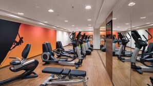 A gym with various exercise equipment, including treadmills and weight machines, arranged in rows. - Courtyard by Marriott Munich City East (Munich)
