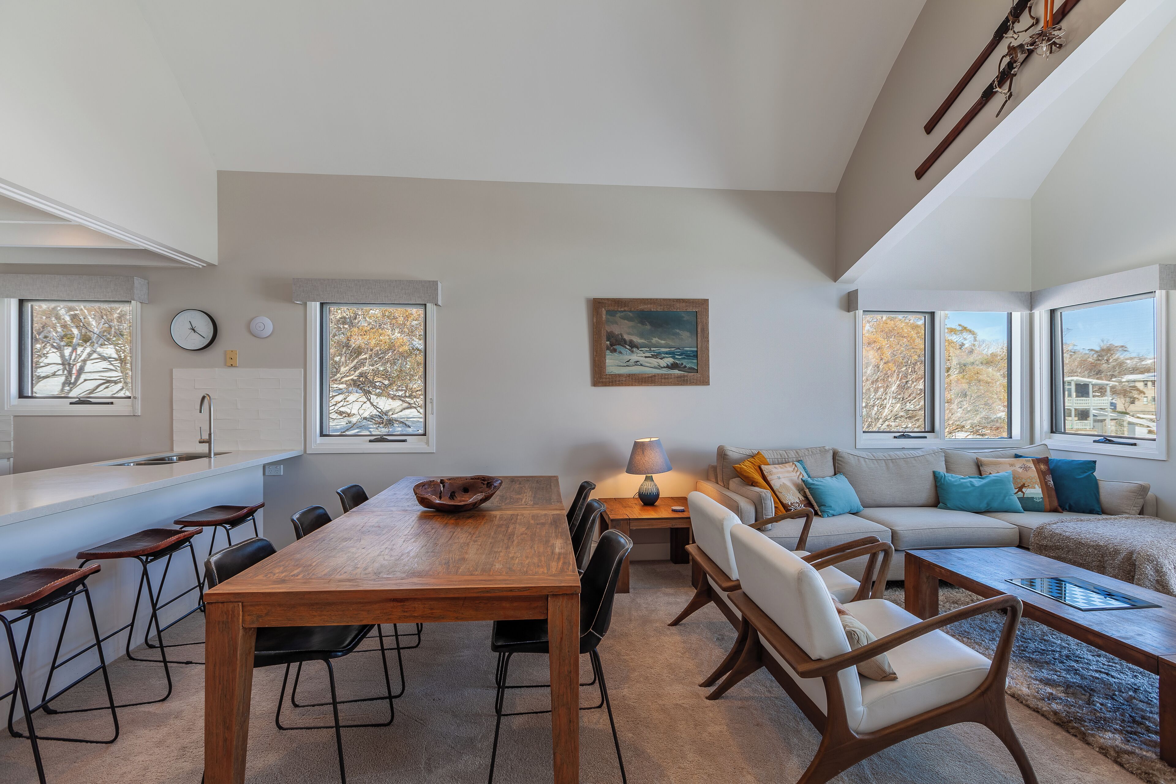 Un espacio habitable moderno con comedor, sofá y un cuadro en la pared.
