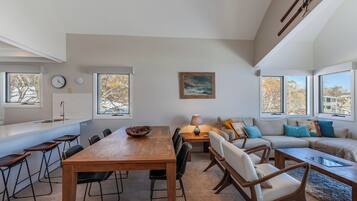 Un espacio habitable moderno con comedor, sofá y un cuadro en la pared.