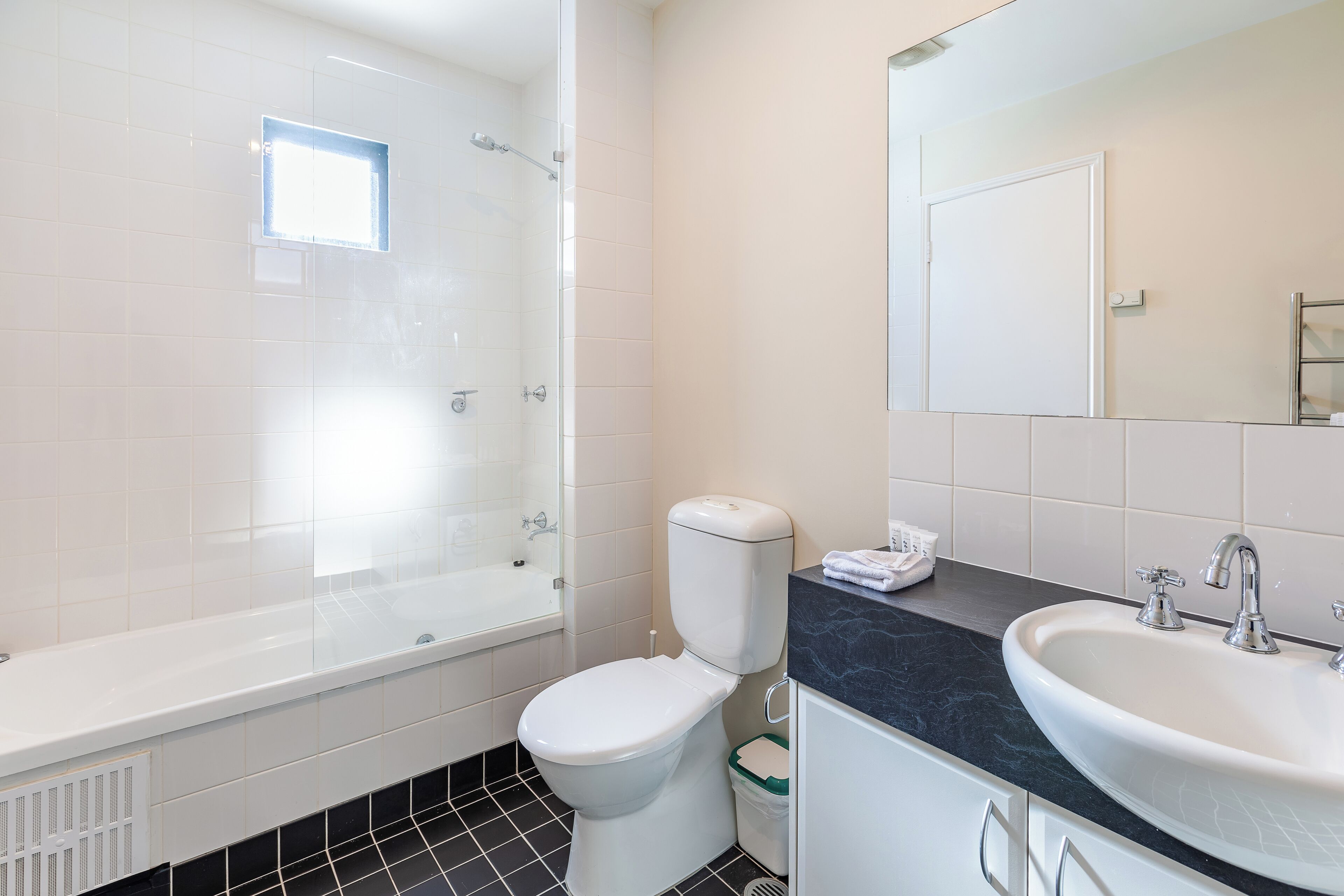 A modern bathroom with a bathtub, toilet, and sink.