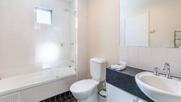 A modern bathroom with a bathtub, toilet, and sink.