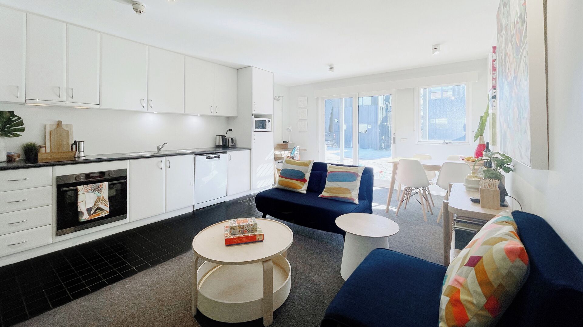 Een modern appartement met keuken, eethoek en woonkamer.