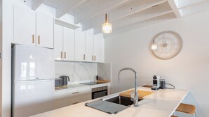 A modern kitchen with white cabinets, a marble countertop, a sink, and a coffee machine. - The Stables Resort Perisher - Open All Year (Perisher Valley)