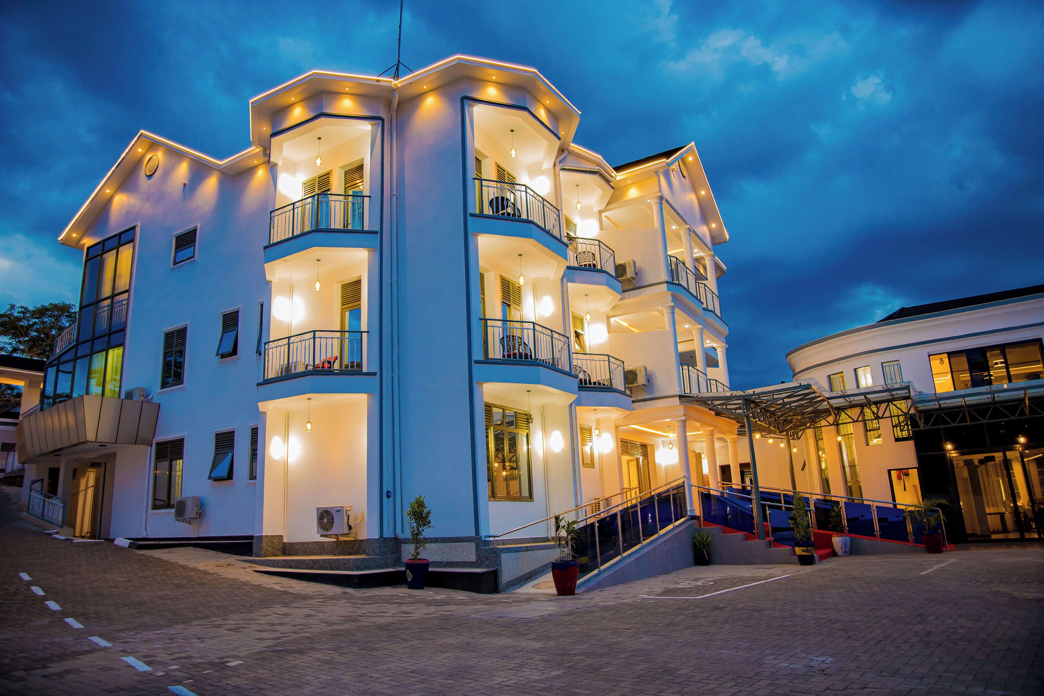 A multi-story hotel with balconies, a covered entrance, and a staircase leading to the upper floors.