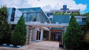 A modern hotel entrance with a glass facade, a staircase, and a sign reading "Royal Crown Hotel". - ROYAL CROWN HOTEL  (Kigali)