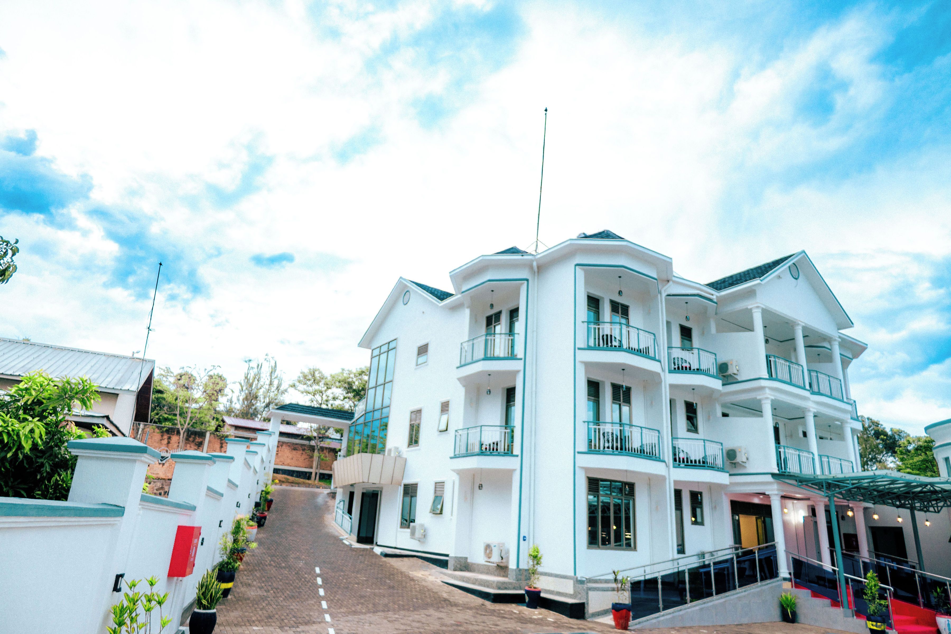 A multi-story hotel with balconies, a covered entrance, and a staircase leading to the entrance.