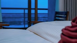 A hotel room with a bed, a chair, and a view of the outside. - ROYAL CROWN HOTEL  (Kigali)