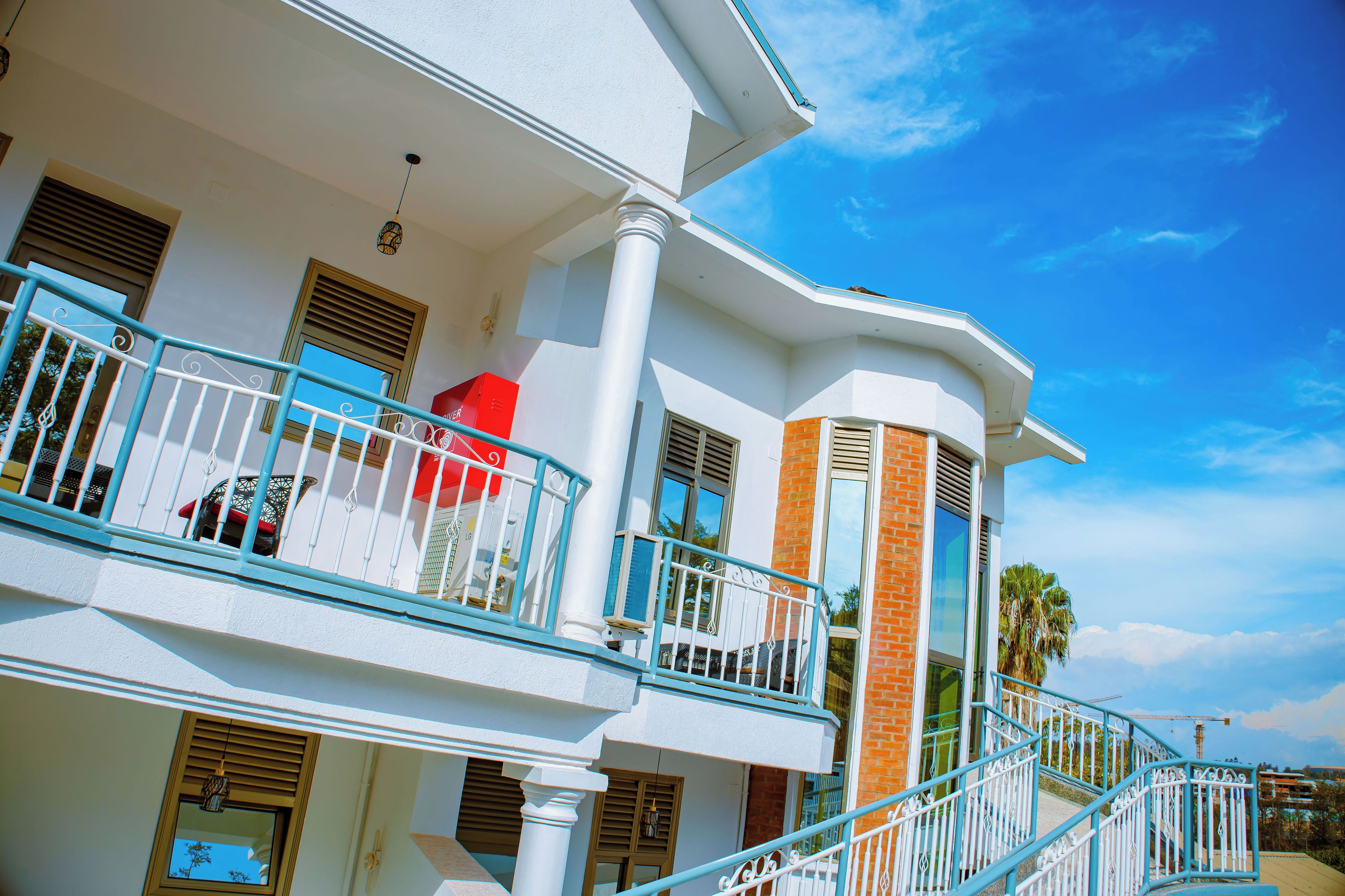 A multi-story building with balconies, large windows, and a clear sky.