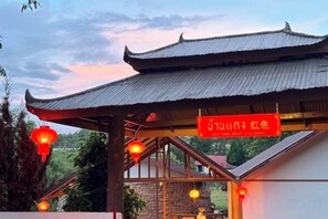 A traditional building with a tiled roof and a sign with Chinese characters. - Baan Daeng Resort (Mae Hong Son)