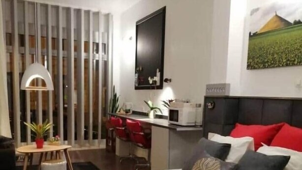 Ein modernes Hotelzimmer mit einem großen Bett, einem Schreibtisch mit Stuhl, einem Fernseher und einem Bild an der Wand.