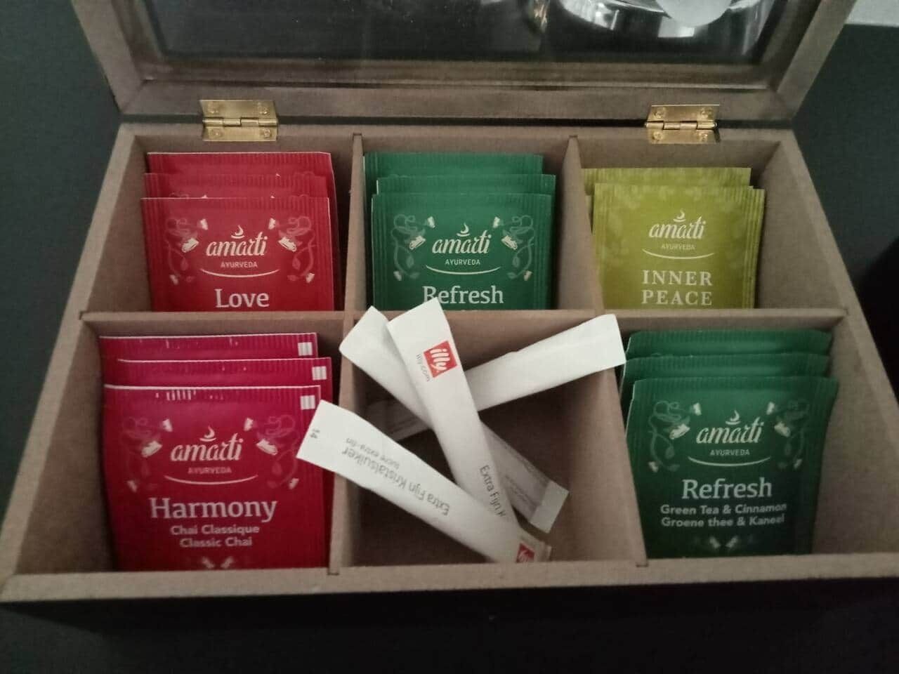 A wooden box containing six tea packets labeled 'Amarti Ayurveda'.