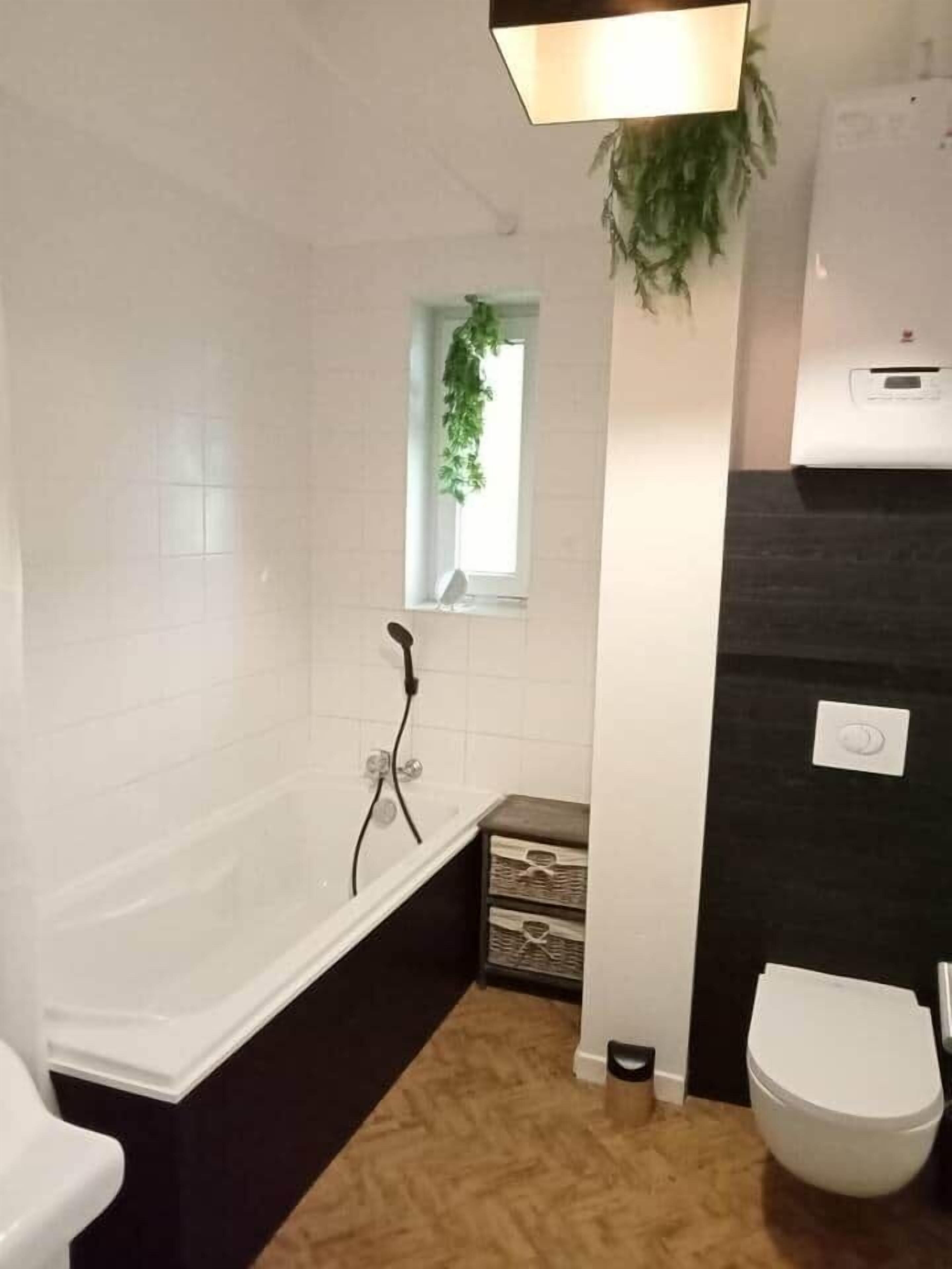 Et badeværelse med badekar, toilet og håndvask.