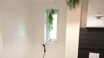 Et badeværelse med badekar, toilet og håndvask.