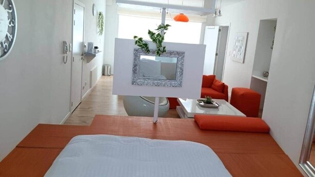 A modern hotel room with a bed, a dining area, and a view of the city. - Head in the clouds - Chez Anastasia (Charleroi)