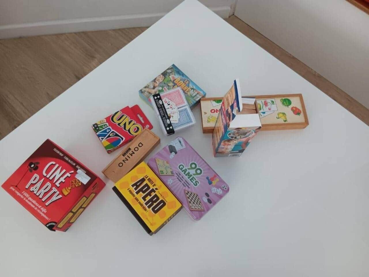 Una mesa blanca con varios juegos de mesa y una caja roja con el rótulo 'Cine Party'.