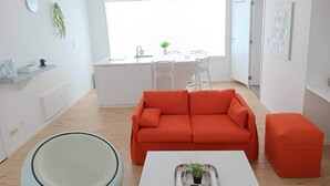 A modern living room with a sofa, ottoman, and a coffee table. - Head in the clouds - Chez Anastasia (Charleroi)