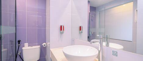 A modern bathroom with a white sink, a toilet, and a shower area.