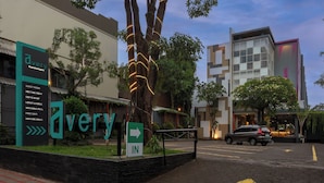 Ein Hotel Eingang mit Schild, das Gästezimmer, Konferenzraum, Café, Lobby-Lounge, Schwimmbad, kostenloses WLAN und Parkplätze anzeigt.