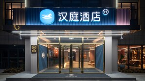 En hotelindgang med et skilt der viser "汉庭酒店" og et logo.