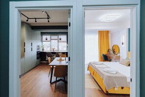 A modern hotel room with a bed, a desk, and a dining area. - Renovated 1BR • City View • Workspace (Chișinău)