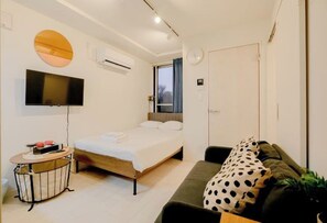 A bedroom with a bed, a TV, a small table, and a window. - Mi-HOTEL KAGURA (Tokyo)