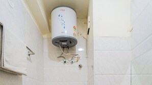 A bathroom with a toilet, a sink, and a shower. - HOTEL CAPITOL SQUARE (Jaipur)