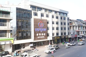 A hotel with a large sign, multiple floors, and a busy street in front. - Joy Hotel (Phnom Penh)