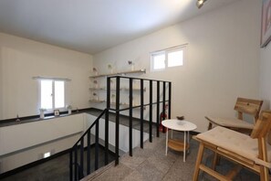 A room with a staircase, a small table, and chairs. - ONU STAY Ikseon (Seoul)