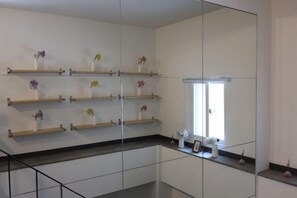 A modern interior with a kitchen area, including a countertop with a sink, a window, and a mirrored wall. - ONU STAY Ikseon (Seoul)