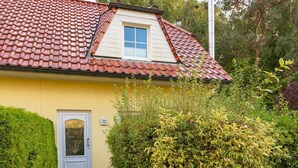 A house with a red-tiled roof, a small window, and a door with a number 32 sign. - Am Deich Haus 32 - Comfortable vacation home on the dike with terrace, garden and (Zingst)
