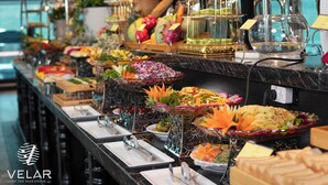 A buffet setup with various food items and decorative elements. - Velar Of The Sea Cruise (Tuan Chau)