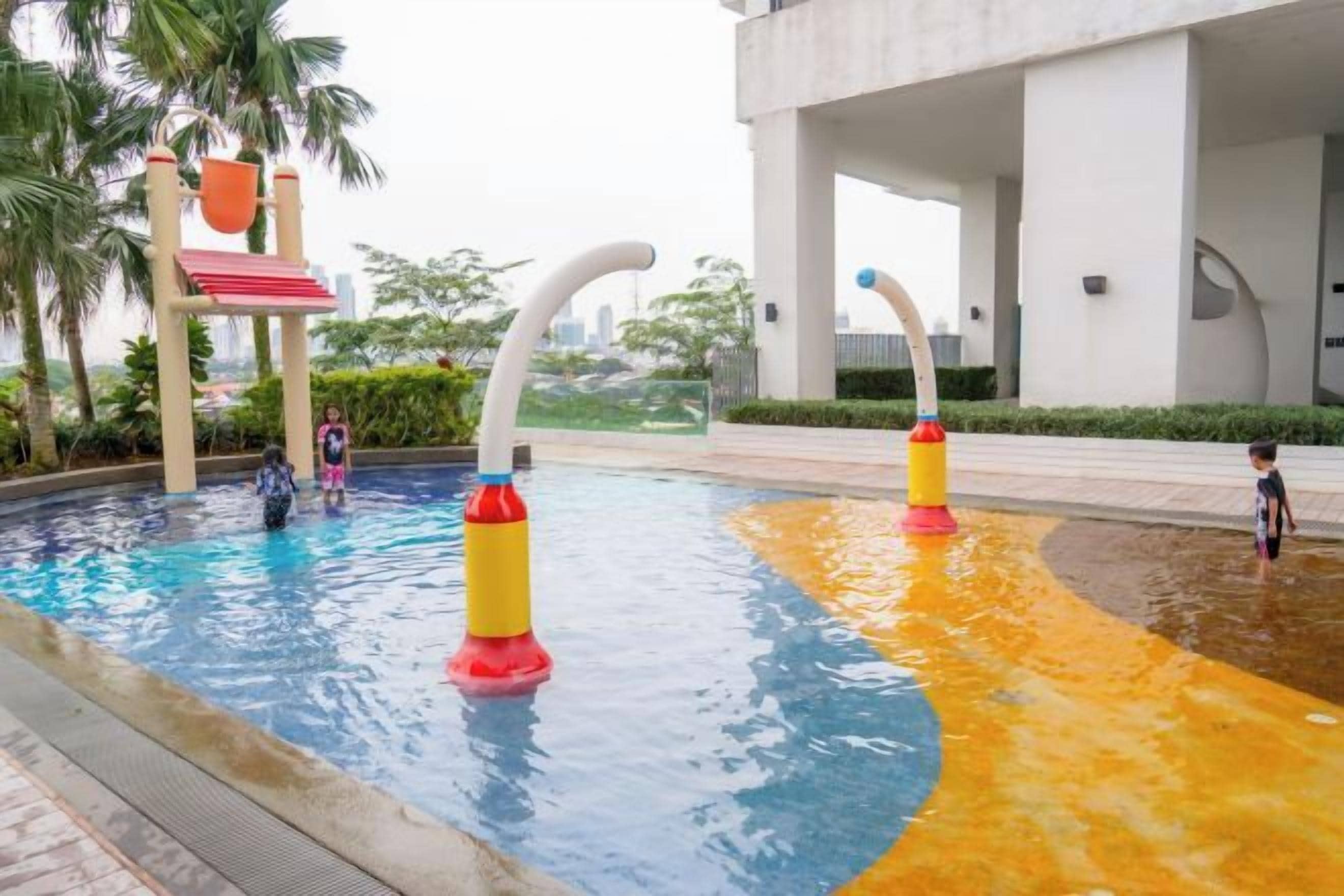 Une piscine avec des toboggans aquatiques et une fontaine.