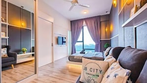 A modern living room with a sofa, a coffee table, a TV, and a large window with curtains. - Mid Valley Southkey Mosaic by RR JBcity (Plentong)