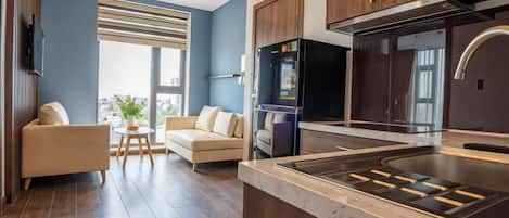 A modern kitchen with a built-in stove, wooden cabinets, and a large window.