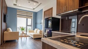 A modern kitchen with a built-in stove, wooden cabinets, and a large window. - Minh Quan Hotel - Da Nang Center by Hos (Da Nang)