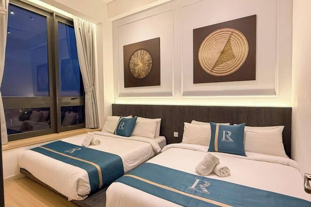 Een hotelkamer met twee bedden, een groot raam met gordijnen en twee kunstwerken aan de muur.