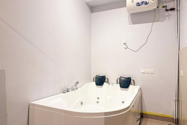 Un baño con una bañera grande, una ducha y un perchero para toallas.