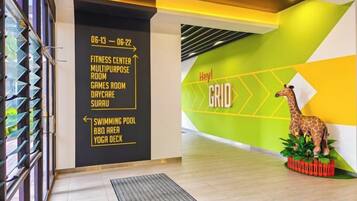 A modern interior with a directional sign, a giraffe decoration, and a geometric wall design.