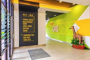 A modern interior with a directional sign, a giraffe decoration, and a geometric wall design. - Sunway Grid by RR JBcity (Iskandar Puteri)