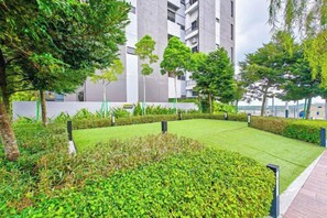A landscaped courtyard with a lawn, hedges, and trees. - Sunway Grid by RR JBcity (Iskandar Puteri)