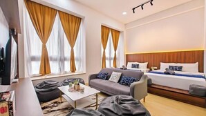 Een hotelkamer met een bed, een bank, een salontafel en een televisie.