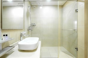 A modern bathroom with a glass-enclosed shower, a white sink, and a mirror above it. - Highvill Hotel (Astana)