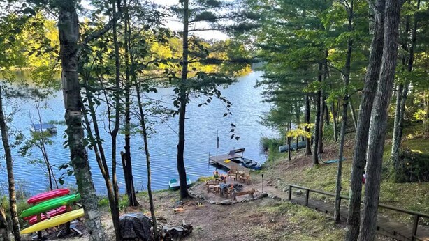 A lakeside campsite with a picnic table and canoe storage. - Spacious Pet-Friendly Lake Home with 2 Kitchens – Perfect for Family Gatherings (Lac du Flambeau)
