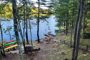 Un terrain de camping au bord du lac, équipé d’une table de pique-nique et d’un espace de rangement pour les canoës.