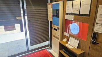 A room with a closed sliding door, a red carpet, and informational posters on the wall.