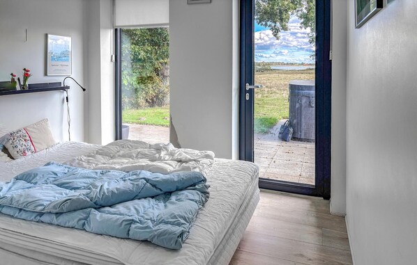 A bedroom with a bed, a window, and a view of the outdoors.