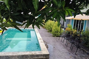 A rectangular pool with a tiled edge, surrounded by a paved walkway. - Bunk Ubon Hostel (Ubon Ratchathani)