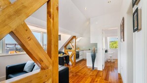 Um interior moderno com escada de madeira, área de jantar e cozinha.